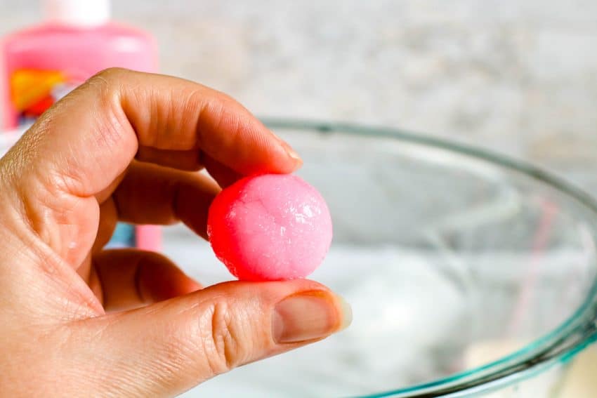 hand holding formed pink bouncy ball after rolling into a ball